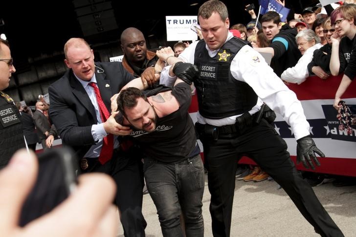 U.S. Secret Service agents detain a man after a disturbance as U.S. Republican presidential candidate Donald Trump spoke at Dayton International Airport in Dayton, Ohio March 12, 2016. REUTERS/William Philpott