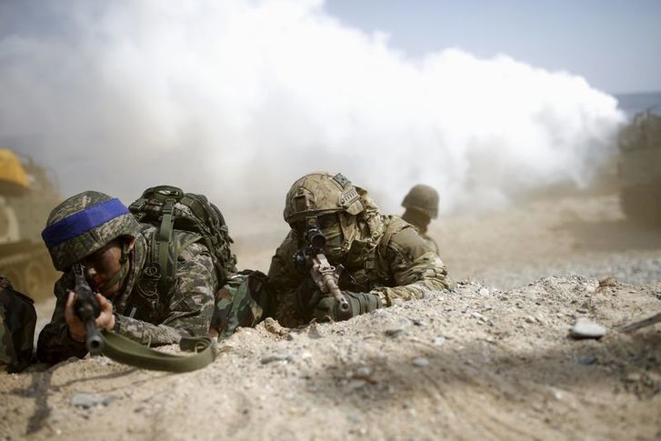 South Korean (blue headbands) and U.S. Marines take part in a U.S.-South Korea joint landing operation drill in Pohang, South Korea, March 12, 2016. REUTERS/Kim Hong-Ji