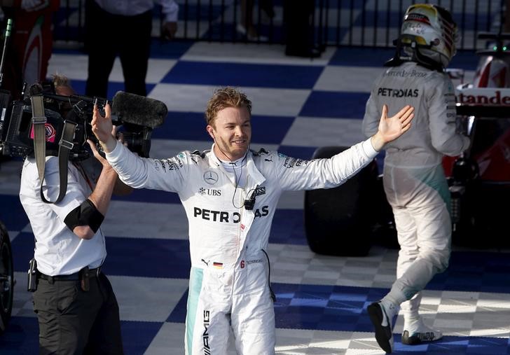 Formula One - Australia Grand Prix - Melbourne, Australia - 20/03/16 - Mercedes F1 driver Nico Rosberg celebrates as his team mate Lewis Hamilton walks behind after winning the Australian Formula One Grand Prix in Melbourne. REUTERS/Jason Reed