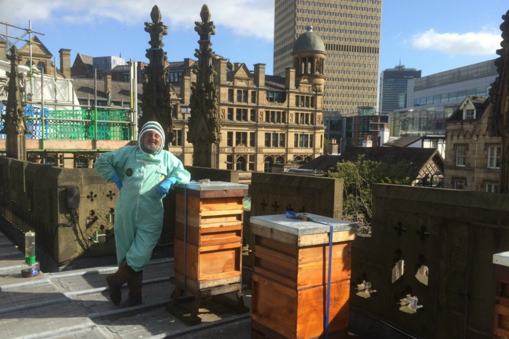 Honorary Canon Adrian Rhodes with his beehives on the roof of Manchester Cathedral. Credit: Copyright 2015 Clarissa Hyman