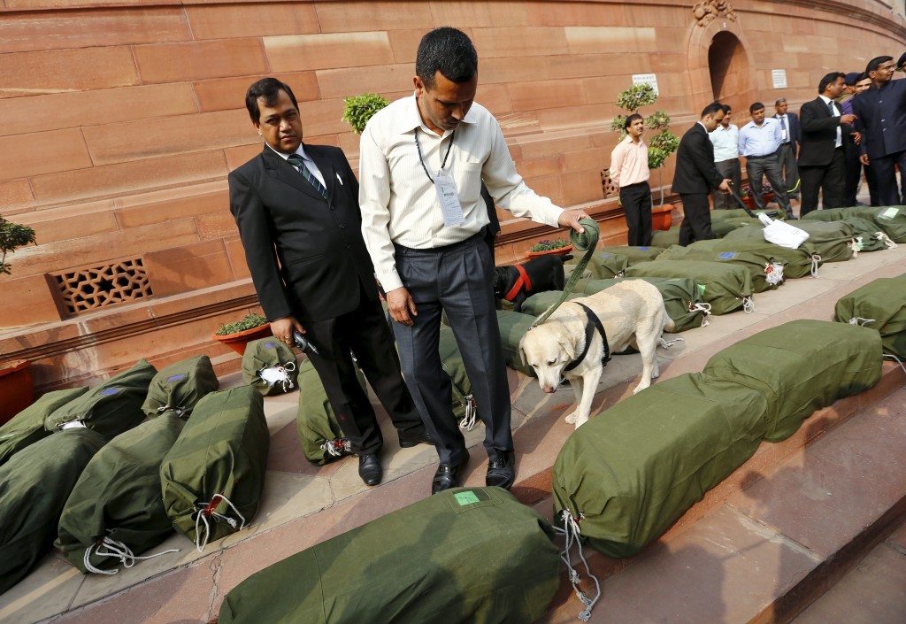 Security force personnel use as a sniffer dog to check bags containing budget papers inside the parliament premises in New Delhi, India, February 29, 2016. REUTERS/Adnan Abidi