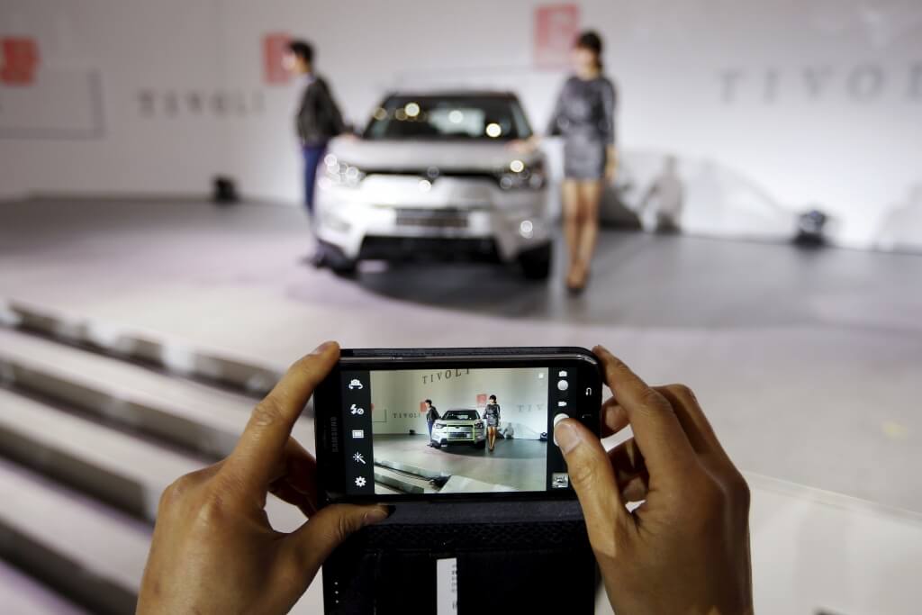 A man takes a photograph of Ssangyong Motor Co's Tivoli during its launch ceremony in Seoul in this January 13, 2015 file photo. REUTERS/Kim Hong-Ji/Files