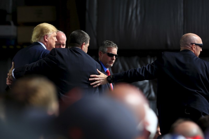 Secret Service agents surround U.S. Republican presidential candidate Donald Trump during a disturbance as he speaks at Dayton International Airport in Dayton, Ohio, March 12, 2016. REUTERS/Aaron P. Bernstein
