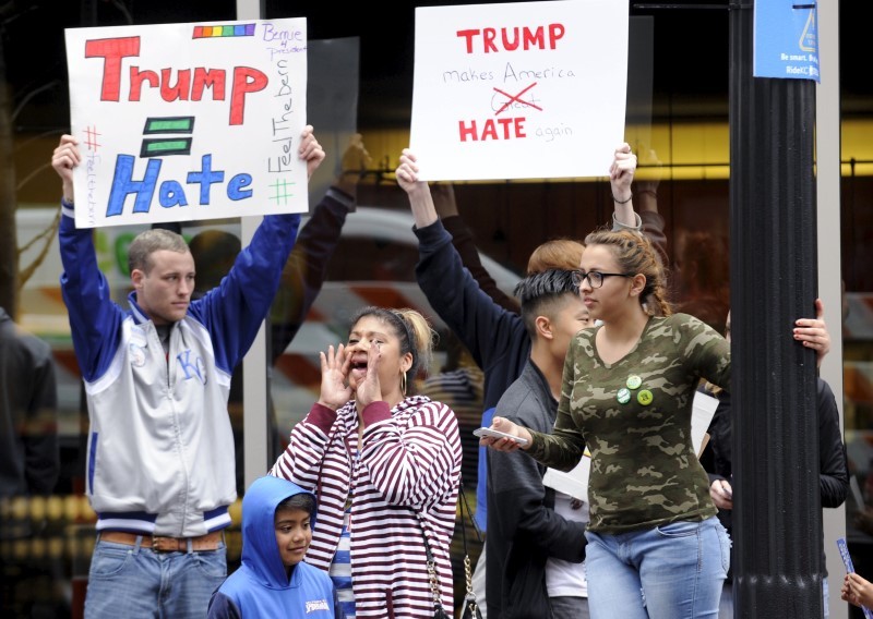 Protesters yell across the street at supporters of U.S. Republican presidential candidate Donald Trump waiting in line for a campaign rally at the downtown Midland Theater in Kansas City, Missouri, March 12, 2016. REUTERS/Dave Kaup