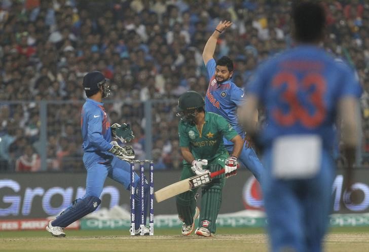 Cricket - India v Pakistan- World Twenty20 cricket tournament - Kolkata, 19/03/2016. Suresh Raina (2nd R) jumps to field the ball off the bat of Pakistan's Ahmed Shehzad as India's captain and wicketkeeper Mahendra Singh Dhoni (L) looks on. REUTERS/Rupak De Chowdhuri